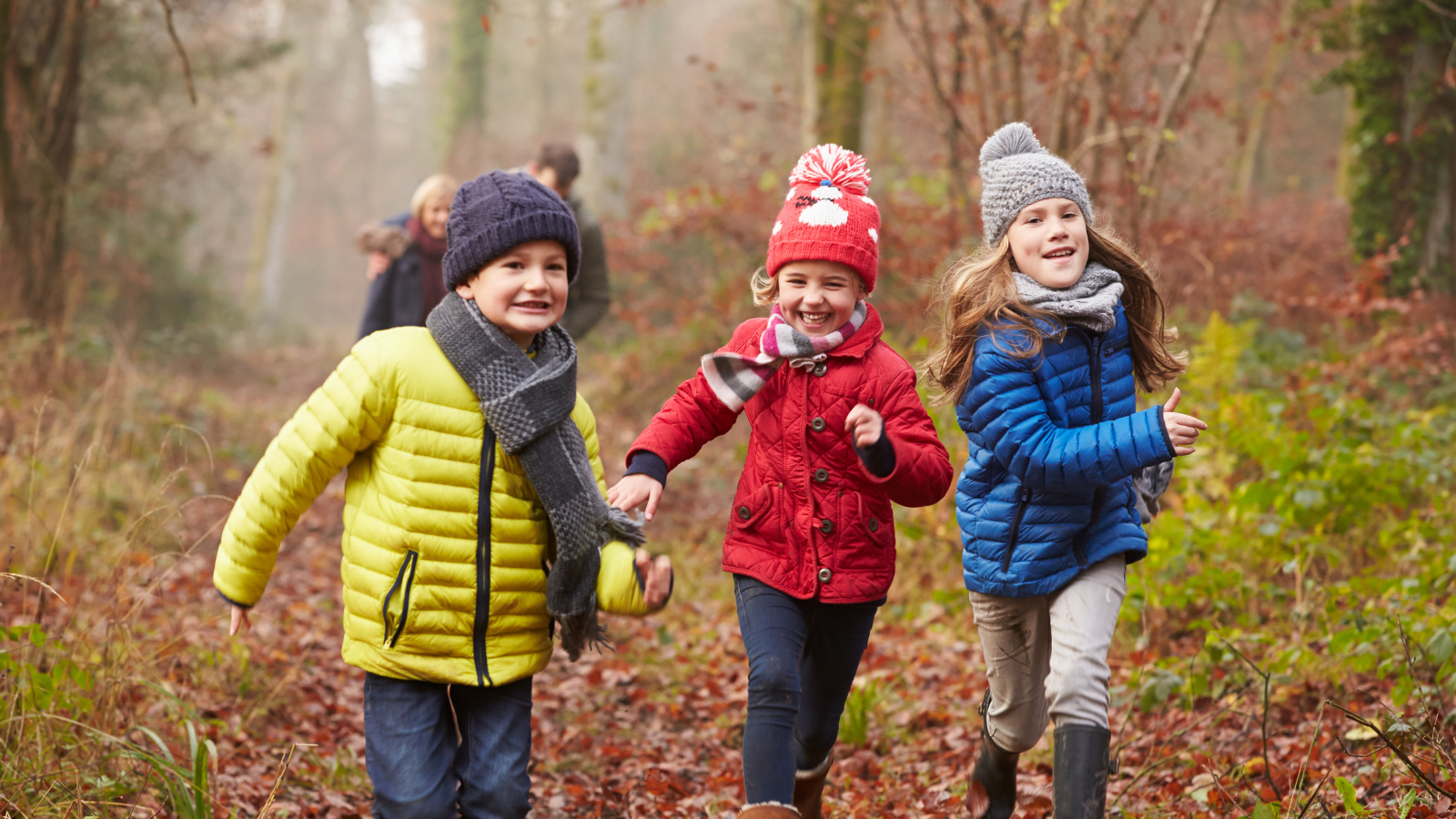 Children running in autumn leaves